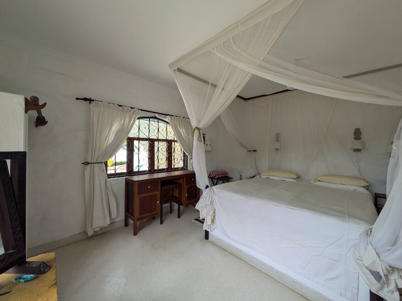 En-suite bedroom with double bed and mosquito net at Marijani Villa Marijani villa bed