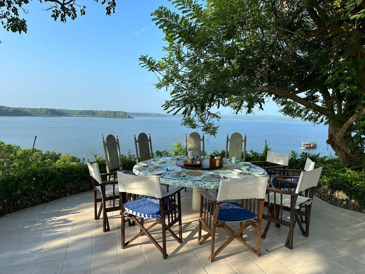 Outdoor dining area under the trees at Marijani Villa Marijani villa water view